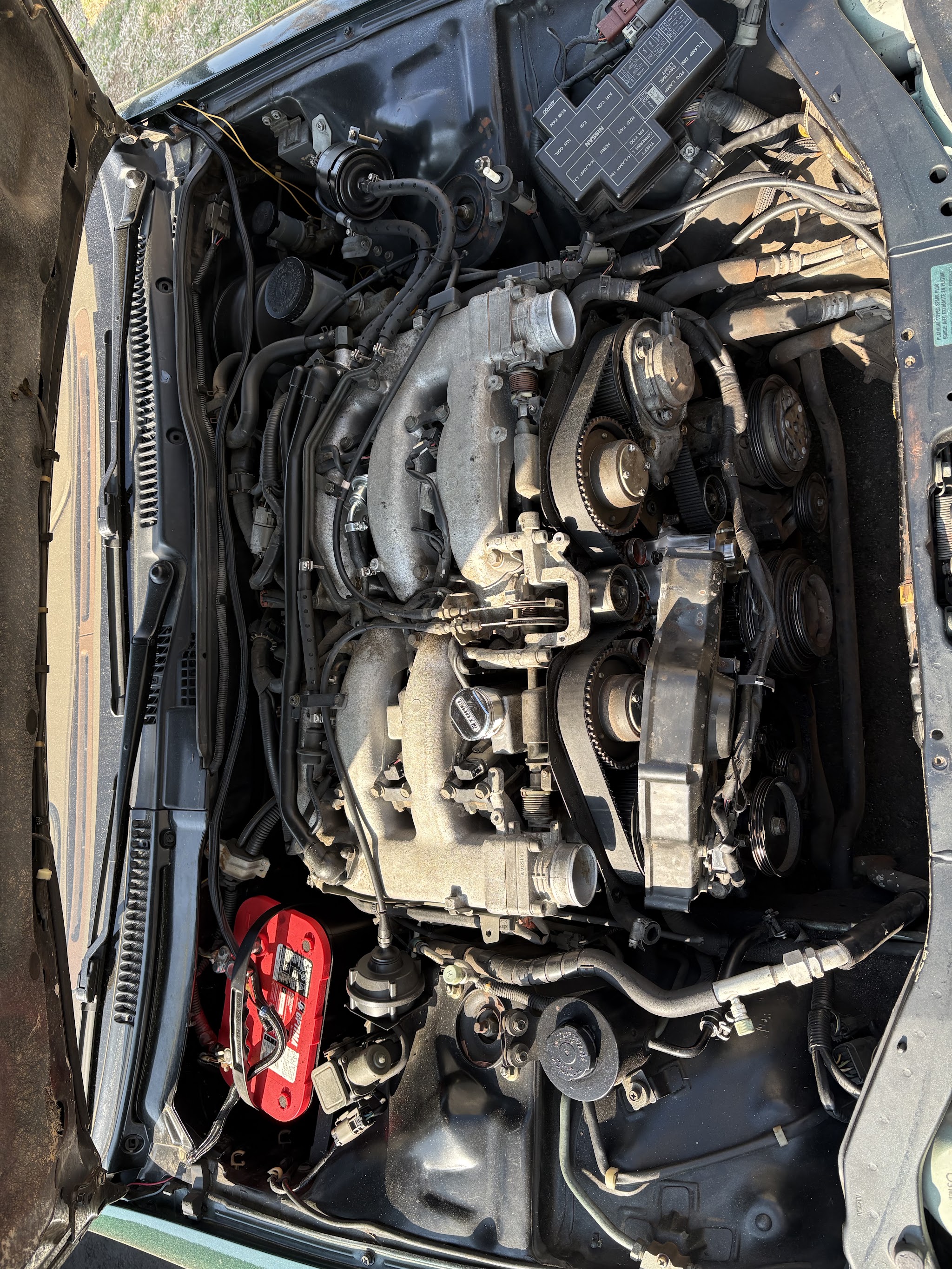 Engine bay of a Nissan seen from above, open for repair
